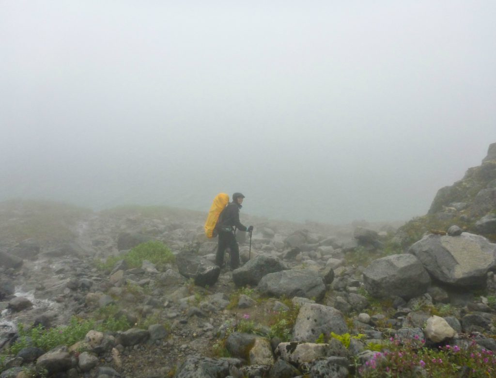 A hiker is engulfed in fog