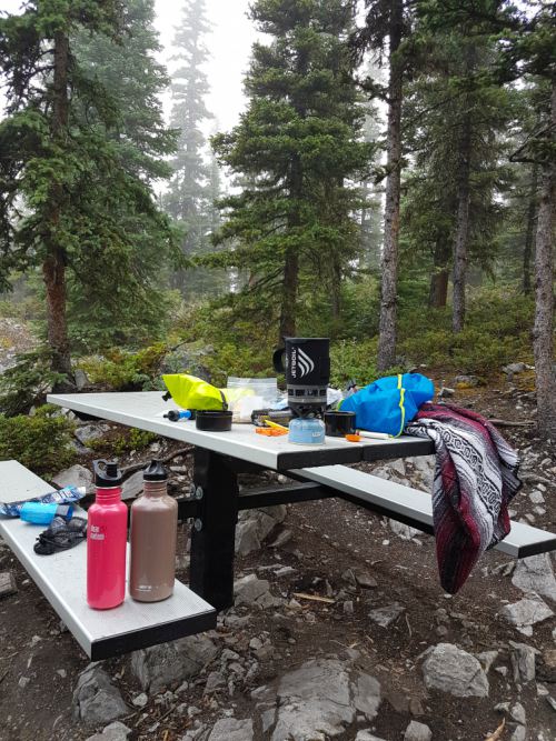 A picnic table with camping supplies