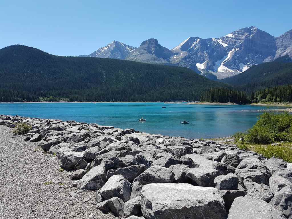 Kayakers on a lake with mountains in the background