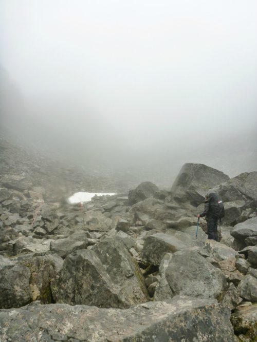 A man hiking the Chilkoot Trail is dwarfed by boulders